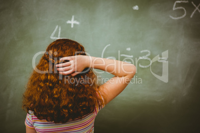 Rear view of little girl looking at blackboard