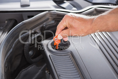Man using dipstick to check oil