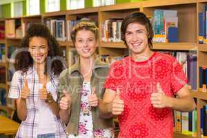 College students gesturing thumbs up in library