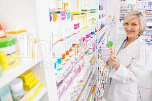 Smiling pharmacist holding prescription and medicine