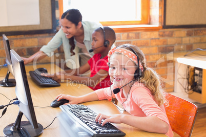 Cute pupils in computer class with teacher