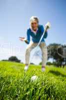 Worried female golfer looking at golf ball