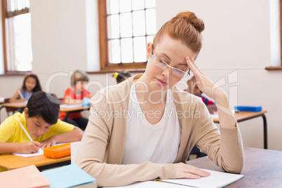 Thinking teacher sitting at desk