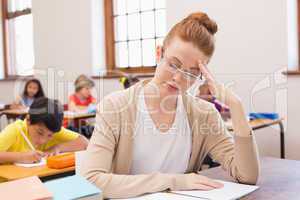 Thinking teacher sitting at desk