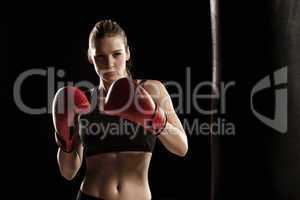 beautiful woman is boxing on black background