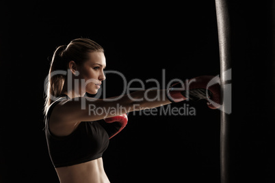beautiful woman is boxing on black background