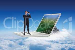 Composite image of elegant businessman standing and using binocu