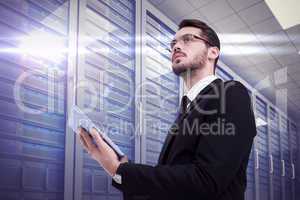 Composite image of businessman looking away while using tablet