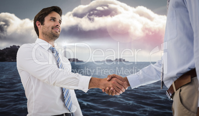 Composite image of young businessmen shaking hands in office