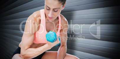 Composite image of strong woman doing bicep curl with blue dumbb