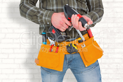 Composite image of manual worker holding gloves and hammer power