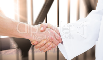 Composite image of closeup of a doctor and patient shaking hands