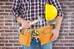 Composite image of repairman with hard hat and hammer