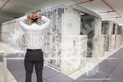 Composite image of businessman standing back to camera hands on