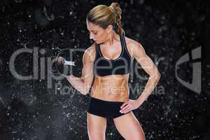 Composite image of female bodybuilder holding large black dumbbe