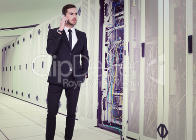Composite image of serious businessman hand in pocket phoning