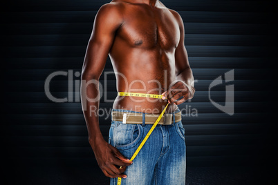 Composite image of mid section of a fit shirtless man measuring