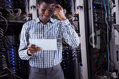 Composite image of young businessman thinking and holding tablet