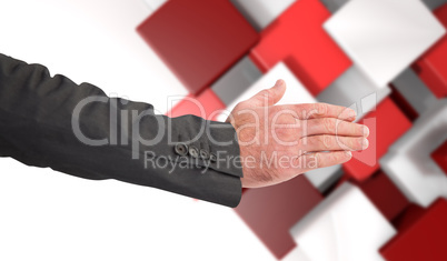 Composite image of businessman reaching hand out