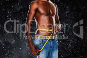 Composite image of mid section of a fit shirtless man measuring