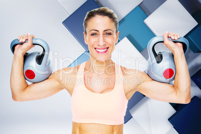 Composite image of happy female crossfitter lifting kettlebells