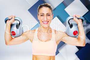 Composite image of happy female crossfitter lifting kettlebells