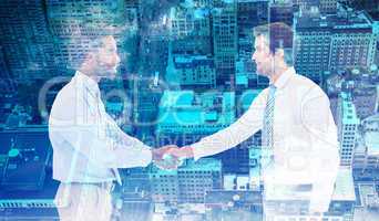 Composite image of smiling young businessmen shaking hands in of