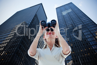 Composite image of businesswoman looking through binoculars