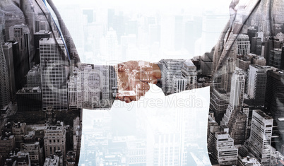 Composite image of close up on two businesspeople shaking hands