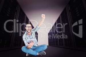 Composite image of handsome hipster using tablet pc and cheering