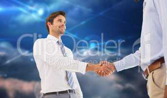 Composite image of young businessmen shaking hands in office