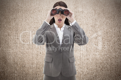 Composite image of surprised businesswoman looking through binoc