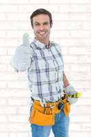 Composite image of happy handyman gesturing thumbs up