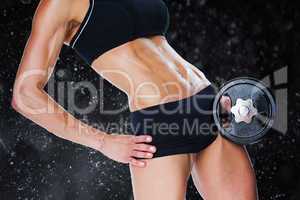 Composite image of female bodybuilder holding large black dumbbe