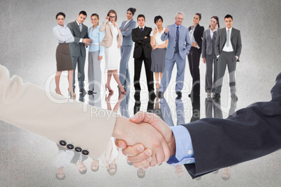 Composite image of smiling business people shaking hands while l