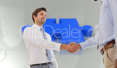 Composite image of young businessmen shaking hands in office