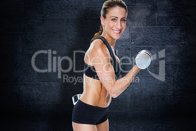 Composite image of female bodybuilder working out with large dum