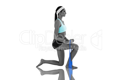 Composite image of fit young woman exercising with a blue yoga b