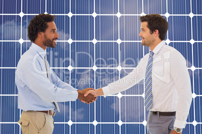 Composite image of smiling young businessmen shaking hands in of