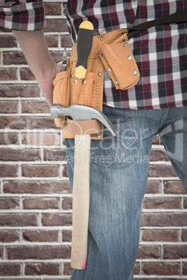 Composite image of cropped image of handyman wearing tool belt