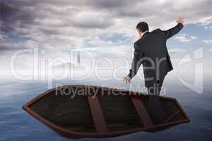 Composite image of businessman balancing in boat