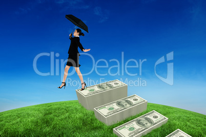 Composite image of young businesswoman holding umbrella