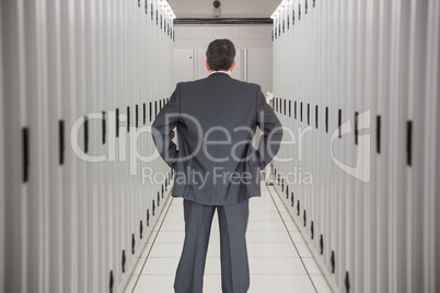 Composite image of businessman standing back to the camera with