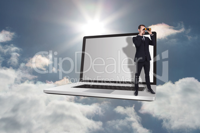 Composite image of elegant businessman standing and using binocu