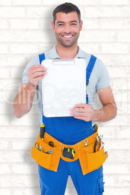 Composite image of portrait of happy repairman showing blank cli