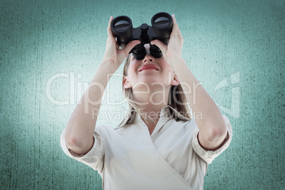 Composite image of businesswoman looking through binoculars