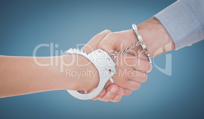 Composite image of handcuffed business people shaking hands