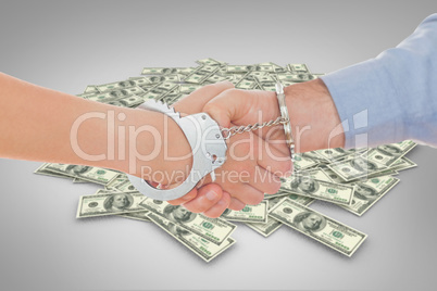 Composite image of handcuffed business people shaking hands