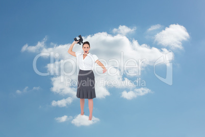 Composite image of angry businesswoman throwing binoculars away