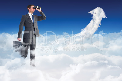 Composite image of businessman looking through binoculars